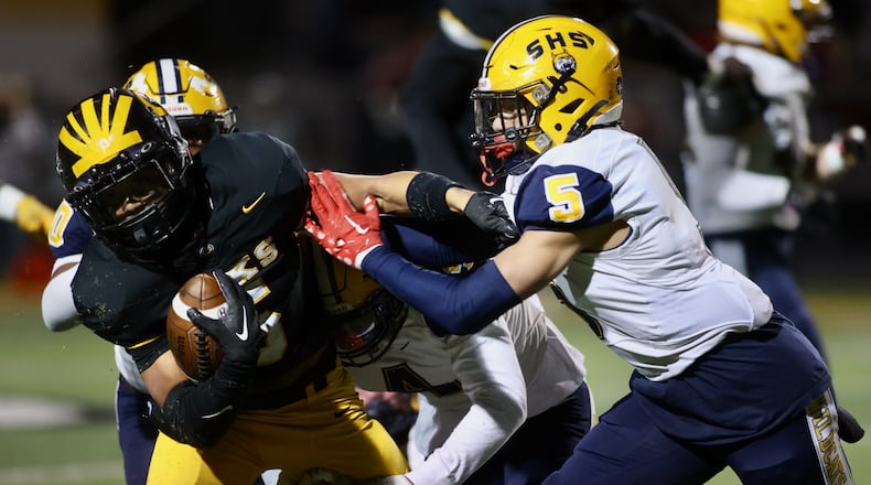 Springfield's Aaron Scott tackles Centerville's Braylon Newcomb in a Division I, Region 2 playoff game on Friday, Nov. 3, 2023, at Centerville. David Jablonski/Staff