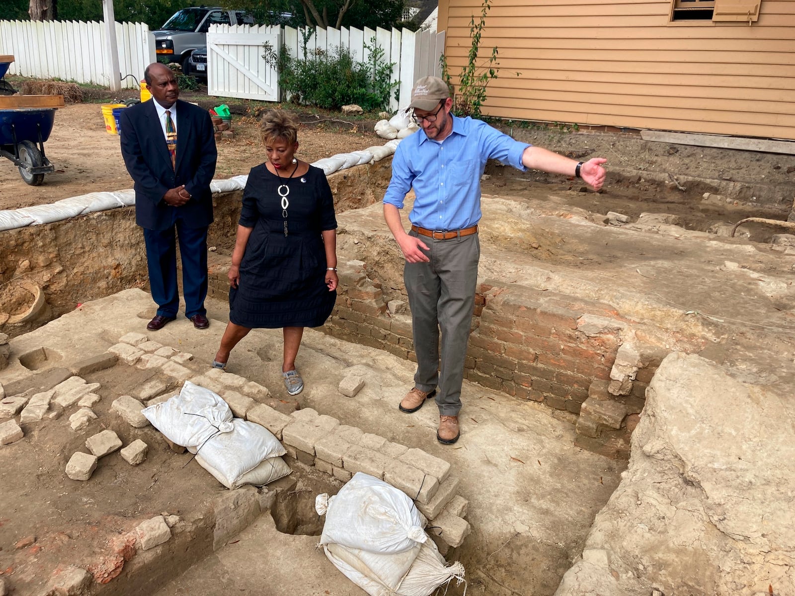 FILE - From left, Reginald F. Davis, pastor of First Baptist Church, Connie Matthews Harshaw, a member of First Baptist, and Jack Gary, Colonial Williamsburg's director of archaeology, stand at the brick-and-mortar foundation of one the oldest Black churches in the U.S. on Oct. 6, 2021, in Williamsburg, Va. (AP Photo/Ben Finley, File)