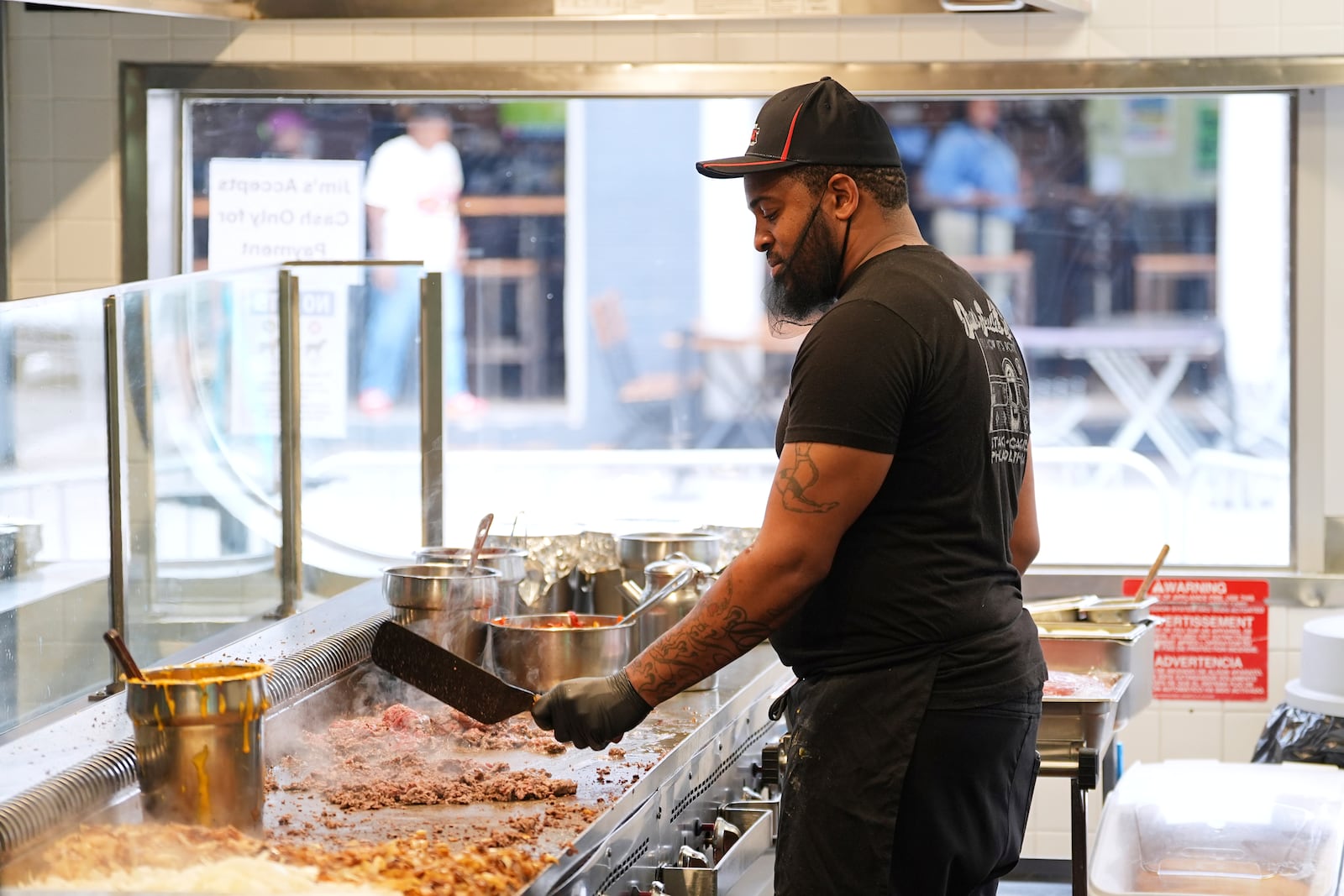 Malik Everett fries beef for a cheesesteak at Jim's South St. in Philadelphia, Wednesday, July 23, 2025. (AP Photo/Matt Rourke)