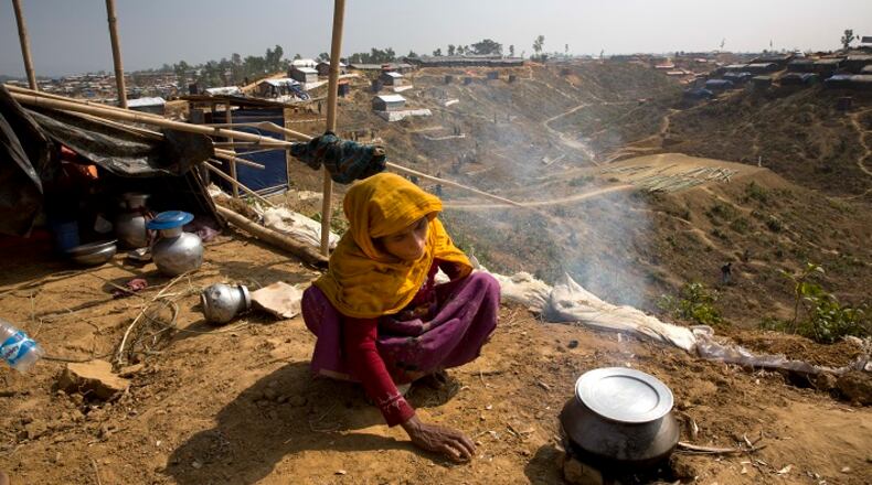 In this Saturday, Jan. 13, 2018, photo, a newly arrived Rohingya woman makes rice for her family at Balukhali refugee camp near Cox's Bazar, Bangladesh. (AP Photo/Manish Swarup)