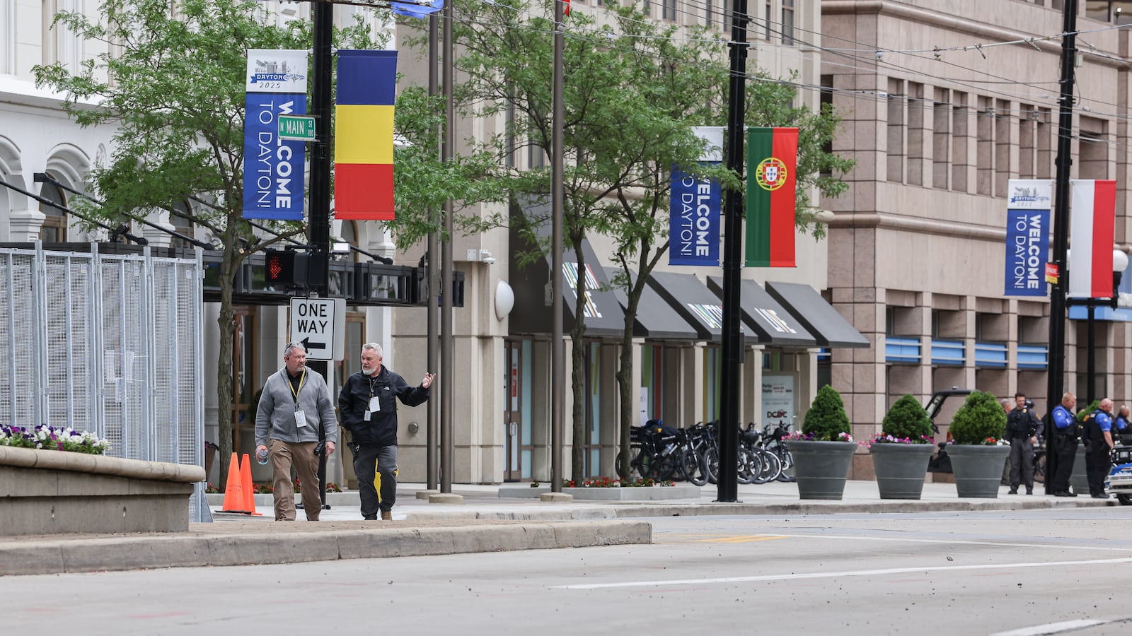 On May 22, 2025, two men walk along North Main Street in downtown Dayton in a security zone that was created for the NATO Parliamentary Assembly. In the background is a property that belongs to Dayton Live that used to be Uno Chicago Bar & Grill. The former restaurant was used as a break area for law enforcement during the event. BRYANT BILLING / STAFF