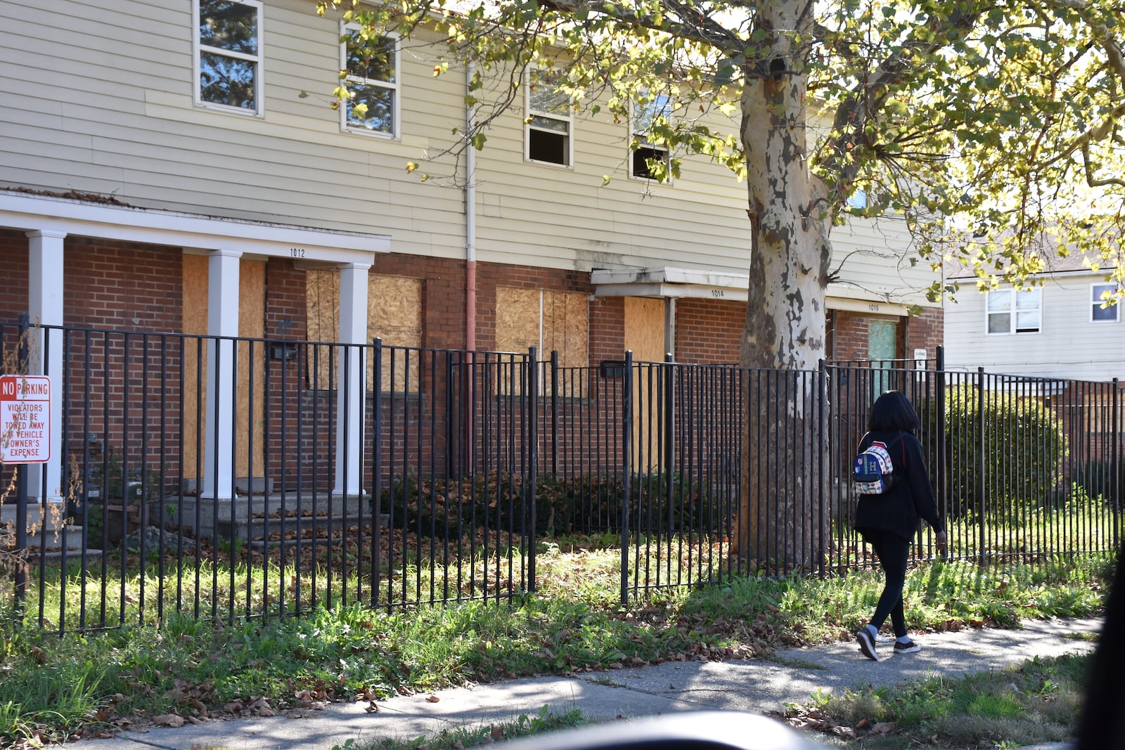 A woman walks by the Bancroft Apartments in West Dayton, which are now vacant and boarded up after the owner lost a Section 8 housing assistance contract with the U.S. Department of Housing and Urban Development. CORNELIUS FROLIK / STAFF