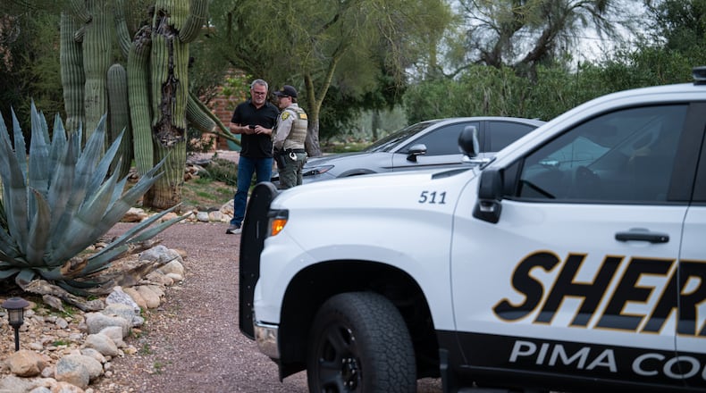 A Pima County Sheriff's deputy talks with a private security guard at Nancy Guthrie's home Thursday, Feb. 5, 2026, in Tucson, Ariz. (AP Photo/Caitlin O'Hara)
