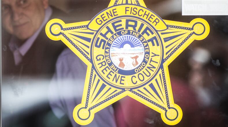 Greene County Sheriff Gene Fischer is seen Monday, April 27, 2020, through the glass door of the sheriff's office bearing his name. JIM NOELKER/STAFF