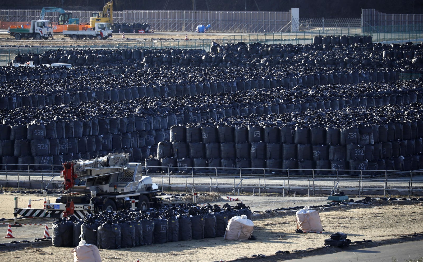 FILE - Black garbage bags filled with radioactivity waste are kept temporally in a field in Minamisoma, Fukushima prefecture, Japan Saturday, March 11, 2017. (Kota Endo/Kyodo News via AP, File)