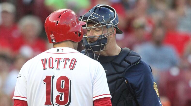 The Reds' Joey Votto argues with the Brewers' Erik Kratz in the third inning on Thursday, June 28, 2018, at Great American Ball Park in Cincinnati.