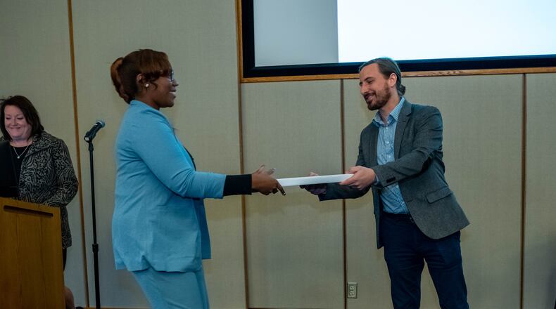 Sinclair Community College's College Credit Plus coordinator, Cyrus Stork, presents Kaeli Wesley her associate degree. Photo courtesy of Sinclair Community College.