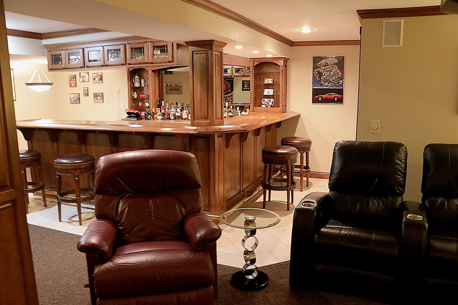 A lower-level media room has a retractable screen with projection system, and a wet bar has a carved counter, brass footrest, bottle and glass shelves and a refrigerator and separate ice maker. CONTRIBUTED PHOTO BY KATHY TYLER
