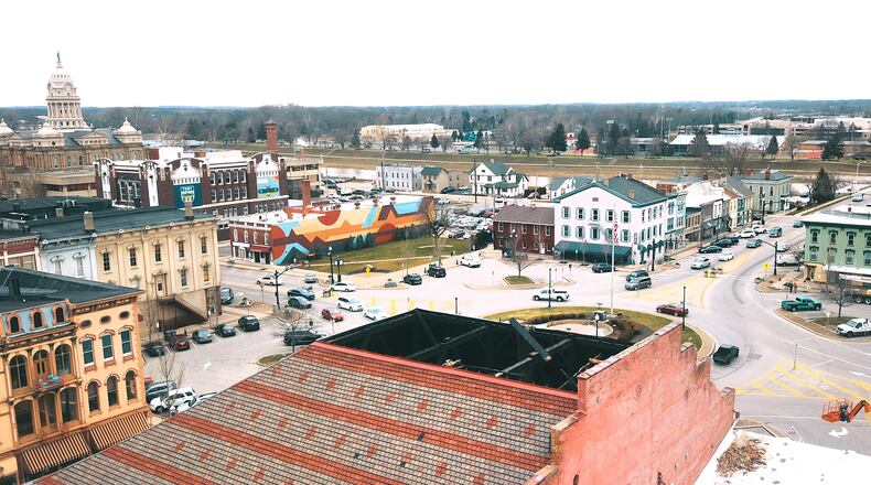 The building that houses The Caroline restaurant at 5 S. Market St. on Troy's town square lost its roof top in a tornado Saturday night. Business owners and residents continued cleaning up Monday after the EF0 tornado, lasting two minutes, touched down in Troy Saturday night damaging buildings and splintering trees. LISA POWELL / STAFF