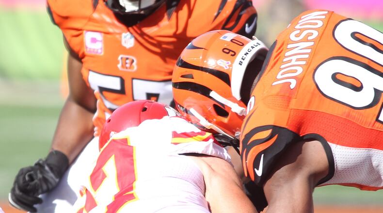 Bengals defensive end Michael Johnson, right, forces a fumble against the Chiefs with a hit on tight end Travis Kelce on Sunday, Oct. 4, 2015, at Paul Brown Stadium in Cincinnati. David Jablonski/Staff