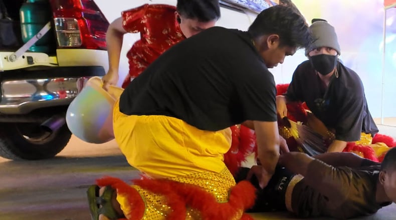 In this image released by Thailand’s Metropolitan Police Bureau, Thai police disguised as lion dance performers catch a burglary suspect at a temple fair in Nonthaburi province, Wednesday, Feb. 18, 2026. (The Metropolitan Police Bureau via AP)