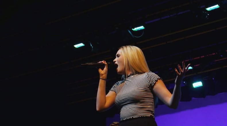 Kettering native, Holly Gyenes performs with Dayton s a capella group, Vocalight. She is shown singing at a benefit concert held recently at Centerville High school. CONTRIBUTED