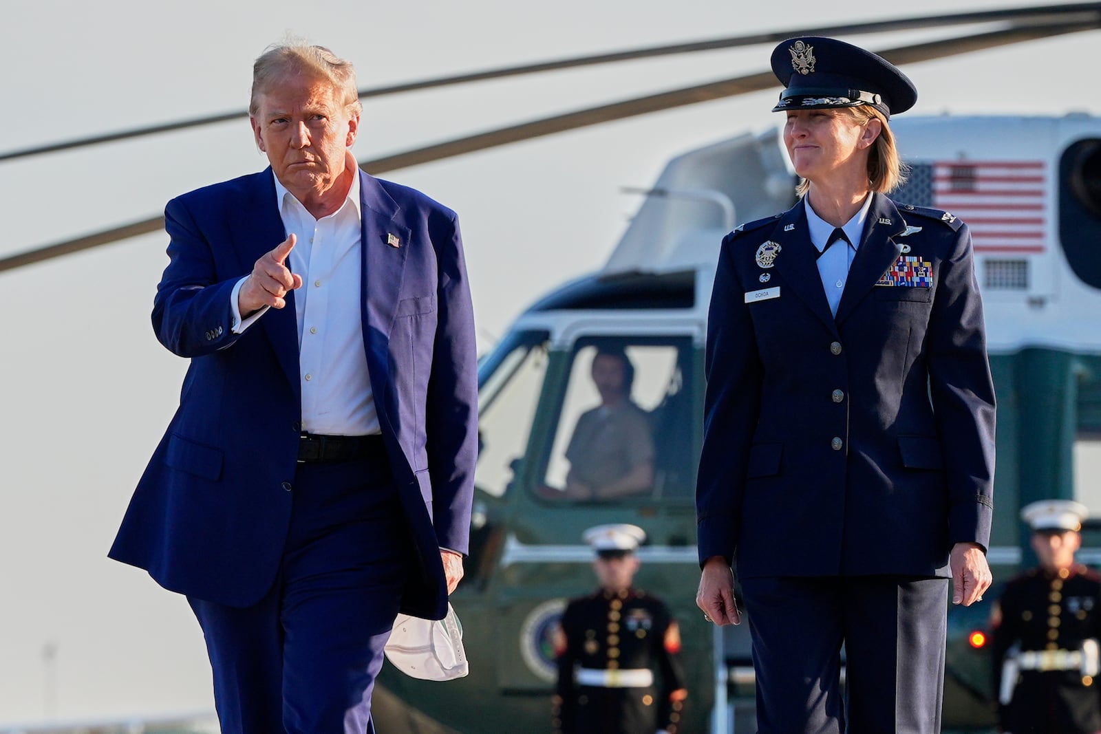 President Donald Trump, left, escorted by Air Force Col. Angela F. Ochoa, Commander, 89th Airlift Wing, walks from Marine One to board Air Force One, Tuesday, June 24, 2025, at Joint Base Andrews, Md. (AP Photo/Alex Brandon)