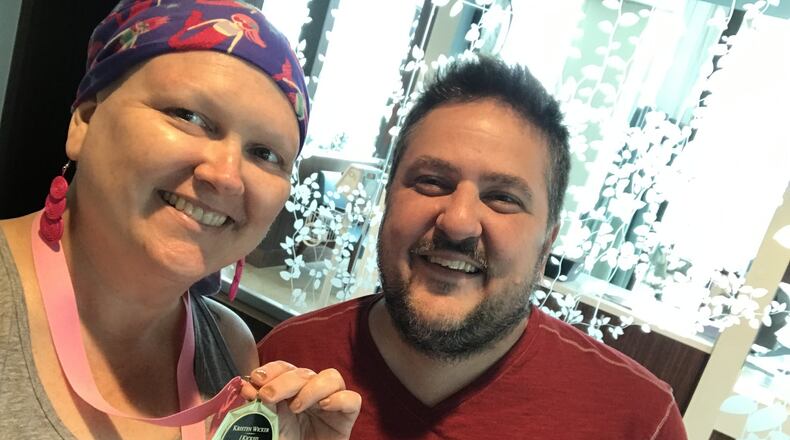 Kristen Wicker (left) and her partner and primary caregiver, Matthew Leclaire, on June 7, the last day of her chemo treatments at the Kettering Cancer Center. Kristen is holding a medal one of her closest friends gave her that day. CONTRIBUTED