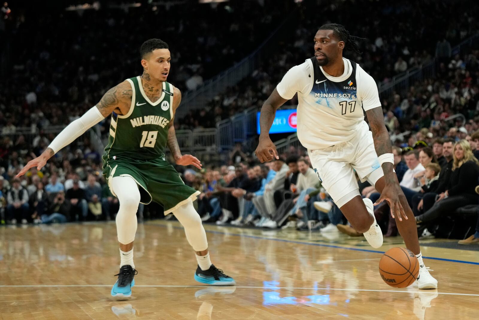 Minnesota Timberwolves' Naz Reid (11) drives to the basket against Milwaukee Bucks' Kyle Kuzma during the second half of an NBA basketball game Tuesday, April 8, 2025, in Milwaukee. (AP Photo/Aaron Gash)