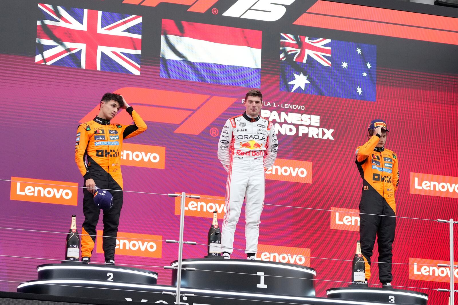 Red Bull driver Max Verstappen of the Netherlands, center, Second placed McLaren driver Lando Norris of Britain, left, and third place McLaren driver Oscar Piastri of Australia, right, stand on the podium after the Japanese Formula One Grand Prix at the Suzuka Circuit in Suzuka, central Japan, Sunday, April 6, 2025. (AP Photo/Hiro Komae)
