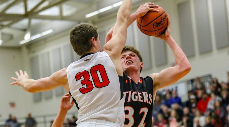 Jackson Center’s Aidan Reichert is defended by Fort Loramie’s Grant Albers during their Division IV regional semifinal game on Tuesday night at Trent Arena in Kettering. The Tigers won 30-25. CONTRIBUTED PHOTO BY MICHAEL COOPER