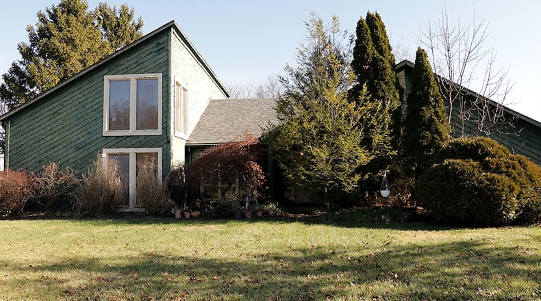 The contemporary-style home offers about 2,480 square feet of living space with 3 to 5 bedrooms. It is nestled among mature landscaping, and a long concrete driveway leads up to the oversized, 2-car, side-entry garage. CONTRIBUTED PHOTO BY KATHY TYLER