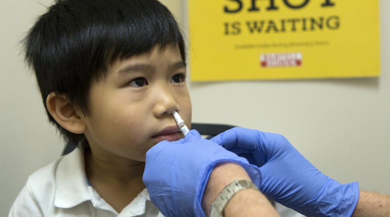 Brayden Yee of Shoreline, Wash., receives a dose of FluMist from a Bartell Drugs pharmacist in December 2014. (Ellen M. Banner/Seattle Times/TNS)