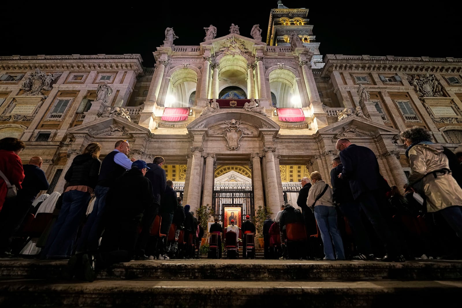 People attend a rosary prayer outside the Santa Maria Maggiore Basilica, where the late Pope Francis will be buried, in Rome, Thursday, April 24, 2025. (AP Photo/Andreea Alexandru)