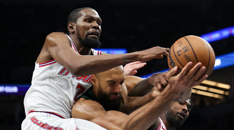 Houston Rockets forward Kevin Durant (7), Minnesota Timberwolves center Rudy Gobert, center, and Houston Rockets guard Amen Thompson, right, compete for a rebound during the first half of an NBA basketball game, Wednesday, March 25, 2026, in Minneapolis. (AP Photo/Ellen Schmidt)