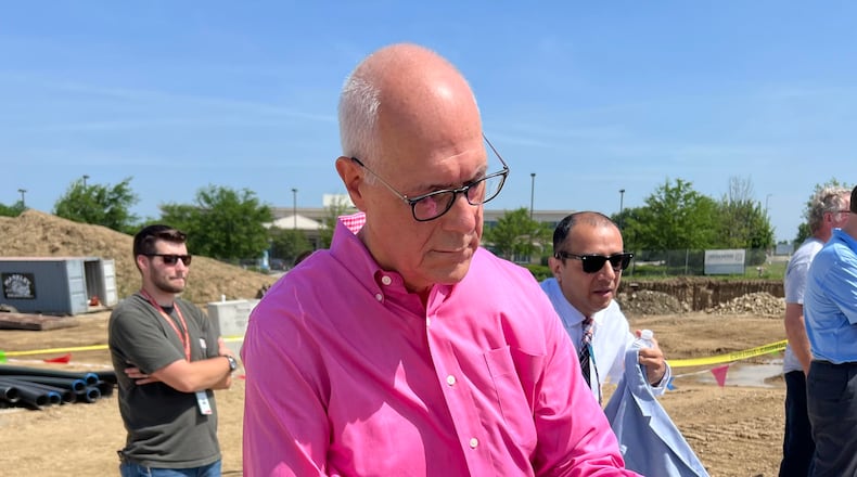 Bear Monita, partner for LWC Inc. architectural firm, signs a brick during Tuesday's commemorative groundbreaking event for the Dayton Metro Library's new Huber Heights branch. The signed bricks will be used in the construction of the facility. LWC is the project architect. AIMEE HANCOCK/STAFF
