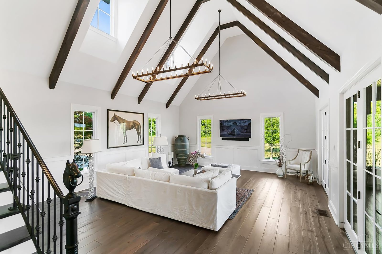 The living room has a beamed, vaulted ceiling, wood floors and exterior doors leading outside to a stamped concrete patio. CONTRIBUTED
