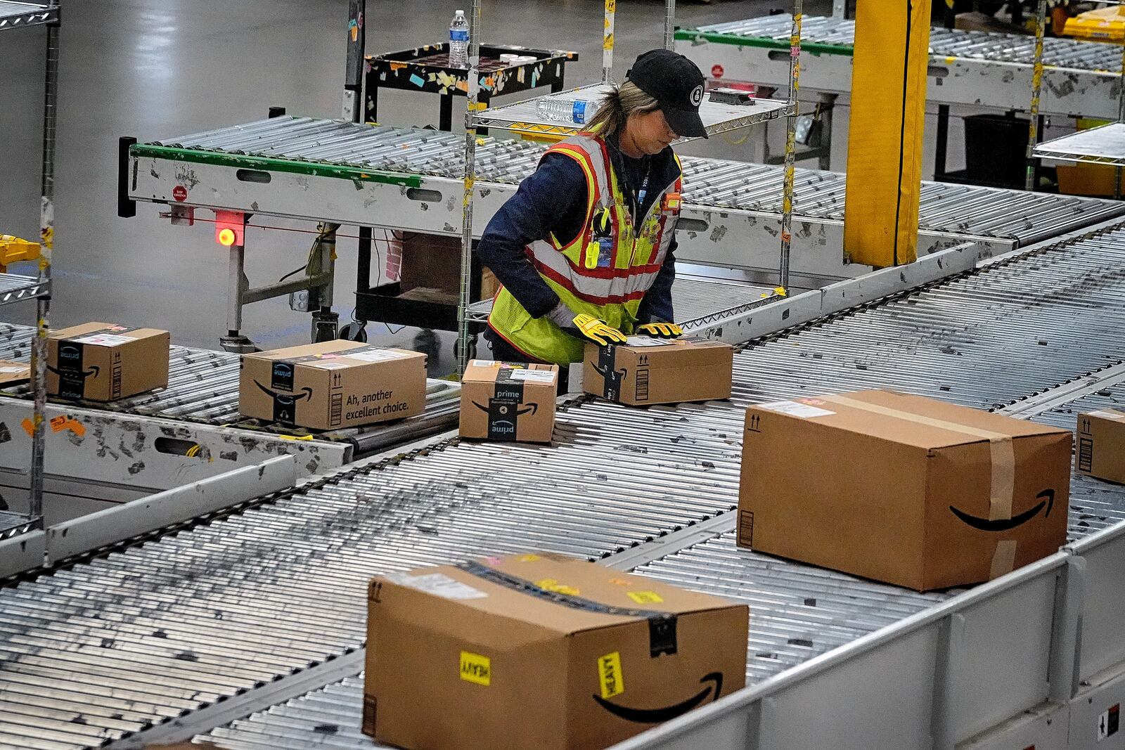 FILE - An Amazon employee puts packages on to a conveyor belt at an Amazon's DAX7 delivery station during Amazon's annual Prime Day event, July 16, 2024, in South Gate, Calif. (AP Photo/Richard Vogel, File)