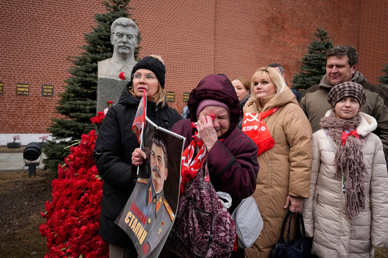 FILE - An elderly woman cries while holding a portrait of Soviet leader Josef Stalin after laying flowers at his grave near the Kremlin Wall in Red Square in Moscow on Wednesday, March 5, 2025, to mark the 72nd anniversary of his death. (AP Photo/Alexander Zemlianichenko, File)