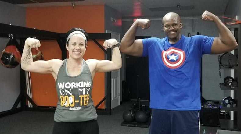 Retired Master Sgt. and financial management specialist Daryl McFadden, flexes with one of his fitness partners, Christina Millard, after a workout. McFadden, who has survived cancer twice and undergone a triple bypass surgery, makes his health his priority by continuing to exercise and changing his eating habits. (Courtesy photo)