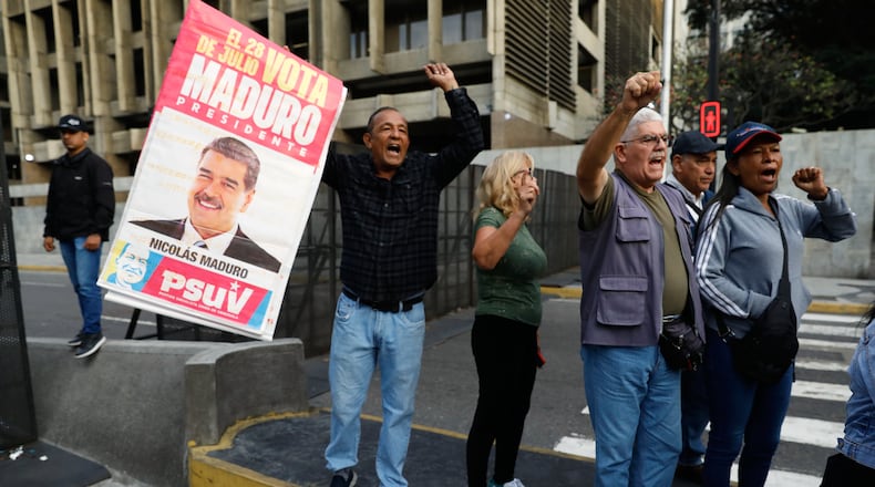 Supporters display a poster of Venezuelan President Nicolás Maduro in Caracas, Venezuela, Saturday, Jan. 3, 2026, after U.S. President Donald Trump announced Maduro had been captured and flown out of the country. (AP Photo/Cristian Hernandez)