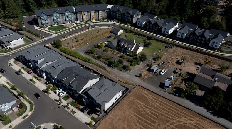 FILE - New construction homes and apartments are seen surrounding an older home on Friday, July 11, 2025, in Happy Valley, Ore. (AP Photo/Jenny Kane, File)