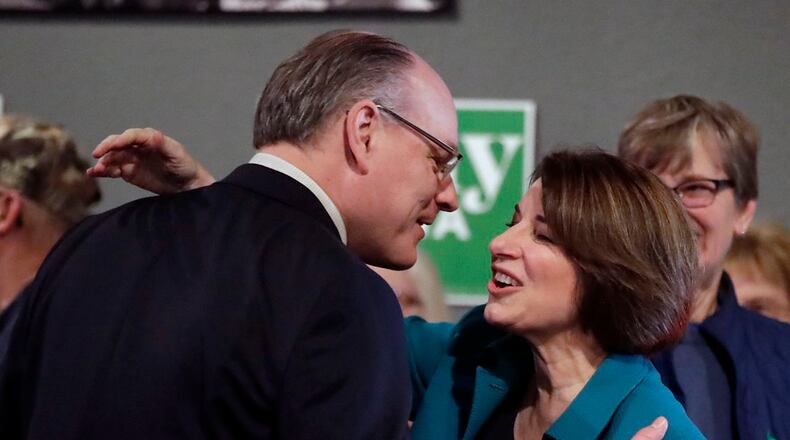 In this Feb. 1, 2020, file photo, then-Democratic presidential candidate Sen. Amy Klobuchar, D-Minn., center, gets a kiss from husband John Bessler, upon arriving at a rally in Sioux City, Iowa. (AP Photo/