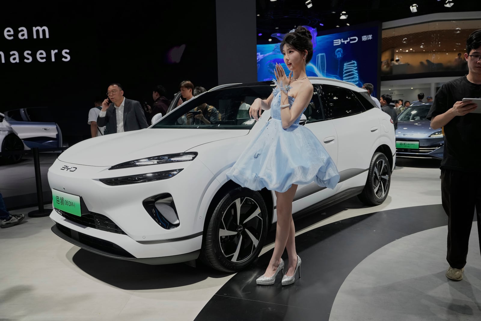 A model poses near the Sea Lion 06 DM-i model from BYD at the Shanghai auto show on Wednesday, April 23, 2025. (AP Photo/Ng Han Guan)