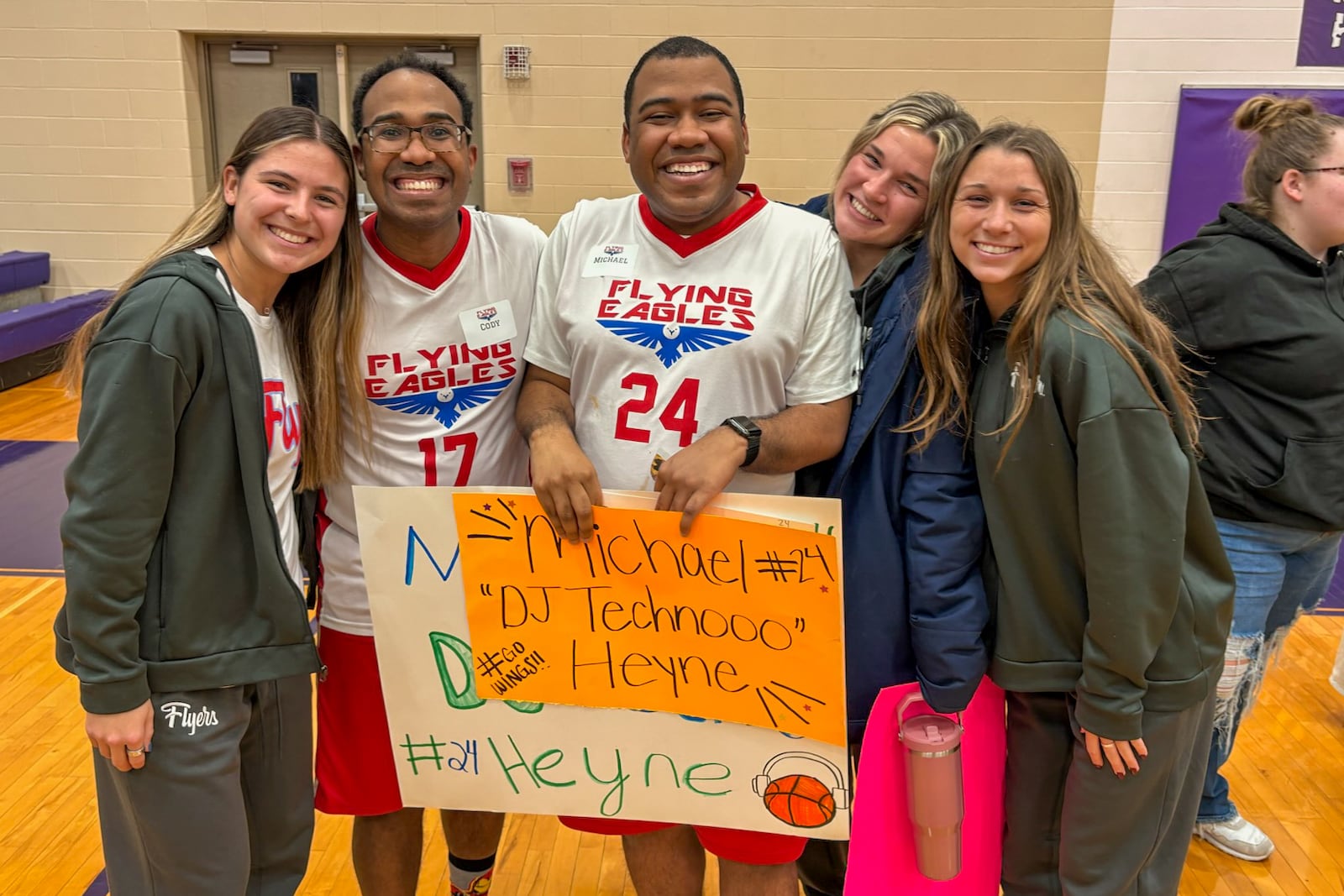 Flying Eagles players Cody Heyne (No. 17) and Michael Heyne (24) with their personalized signs are surrounded by UD soccer players who made much of the artwork and cheered them to victory Monday night. TOM ARCHDEACON / CONTRIBUTED PHOTO