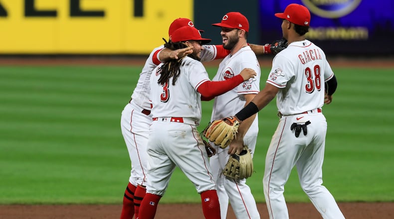 Cincinnati Reds' Joey Votto, back left, Freddy Galvis, second from left, Mike Moustakas, middle, and Jose Garcia celebrate after the Reds defeated the Pittsburgh Pirates 1-0 in a baseball game Wednesday, Sept. 16, 2020, in Cincinnati. (AP Photo/Aaron Doster)