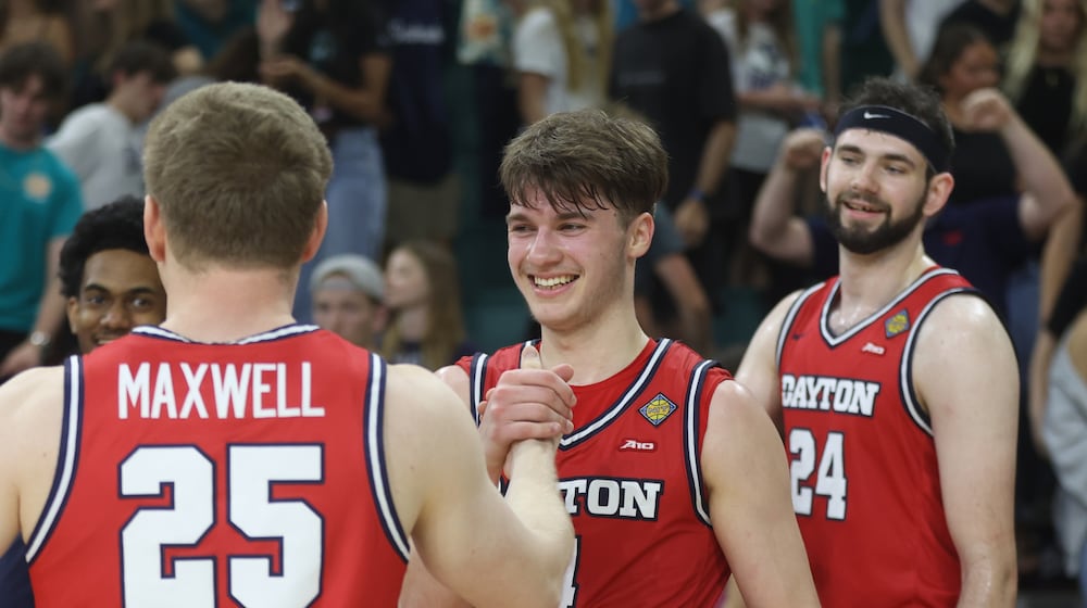 Dayton's Jordan Derkack, center, shakes hands with Will Maxwell after a victory against North Carolina Wilmington in the first round of the National Invitation Tournament on Saturday, March 21, 2026, at Trask Coliseum in Wilmington, N.C.. David Jablonski/Staff