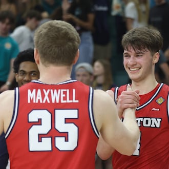 Dayton's Jordan Derkack, center, shakes hands with Will Maxwell after a victory against North Carolina Wilmington in the first round of the National Invitation Tournament on Saturday, March 21, 2026, at Trask Coliseum in Wilmington, N.C.. David Jablonski/Staff