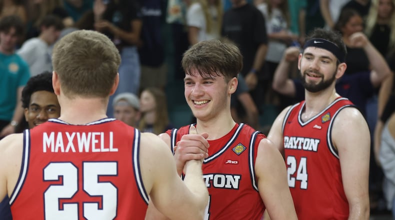 Dayton's Jordan Derkack, center, shakes hands with Will Maxwell after a victory against North Carolina Wilmington in the first round of the National Invitation Tournament on Saturday, March 21, 2026, at Trask Coliseum in Wilmington, N.C.. David Jablonski/Staff