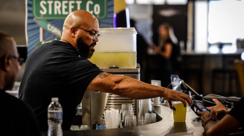 Taco Street Co. owner Anthony Thomas fixes drinks at his store inside W. Social Tap and Table at 1100 West Third St. JIM NOELKER/STAFF