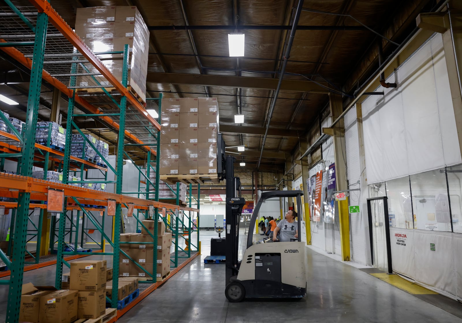 Warehouse picker Jennifer Payton uses forklift to pull down boxes of Frito-Lay chips at Second Harvest Food Bank on Wednesday, July 9, 2025, in Springfield. JOSEPH COOKE/STAFF