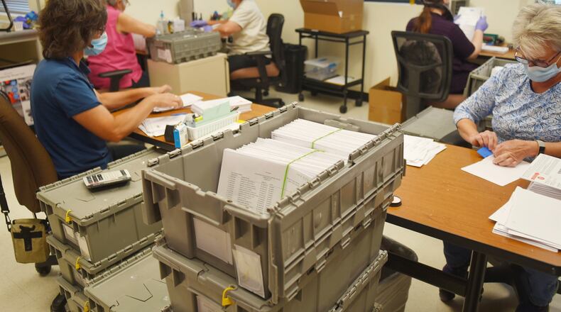 Yavapai County election officials separate signatures from ballots for the Arizona primary at the Yavapai County Administrative Services building in Prescott, Ariz., Aug. 1, 2020. Three residents in rural Arizona filled out and forged their recently deceased spouses' signatures on mailed ballots in the 2020 Presidential election and then sent them to their election department. All were caught and charged with voter fraud. But the punishments they received were different. One, a Republican, negotiated a misdemeanor plea deal, and his conviction was swiftly vacated weeks later. The others, both Democrats, did not get a misdemeanor option and made felony guilty pleas, lost their voting rights and remain on probation. Yavapai County prosecutors defend their handling of the cases and say party affiliation played no role, but two former prosecutors say they create a perception of favoritism. (Jesse Bertel/The Daily Courier via AP)