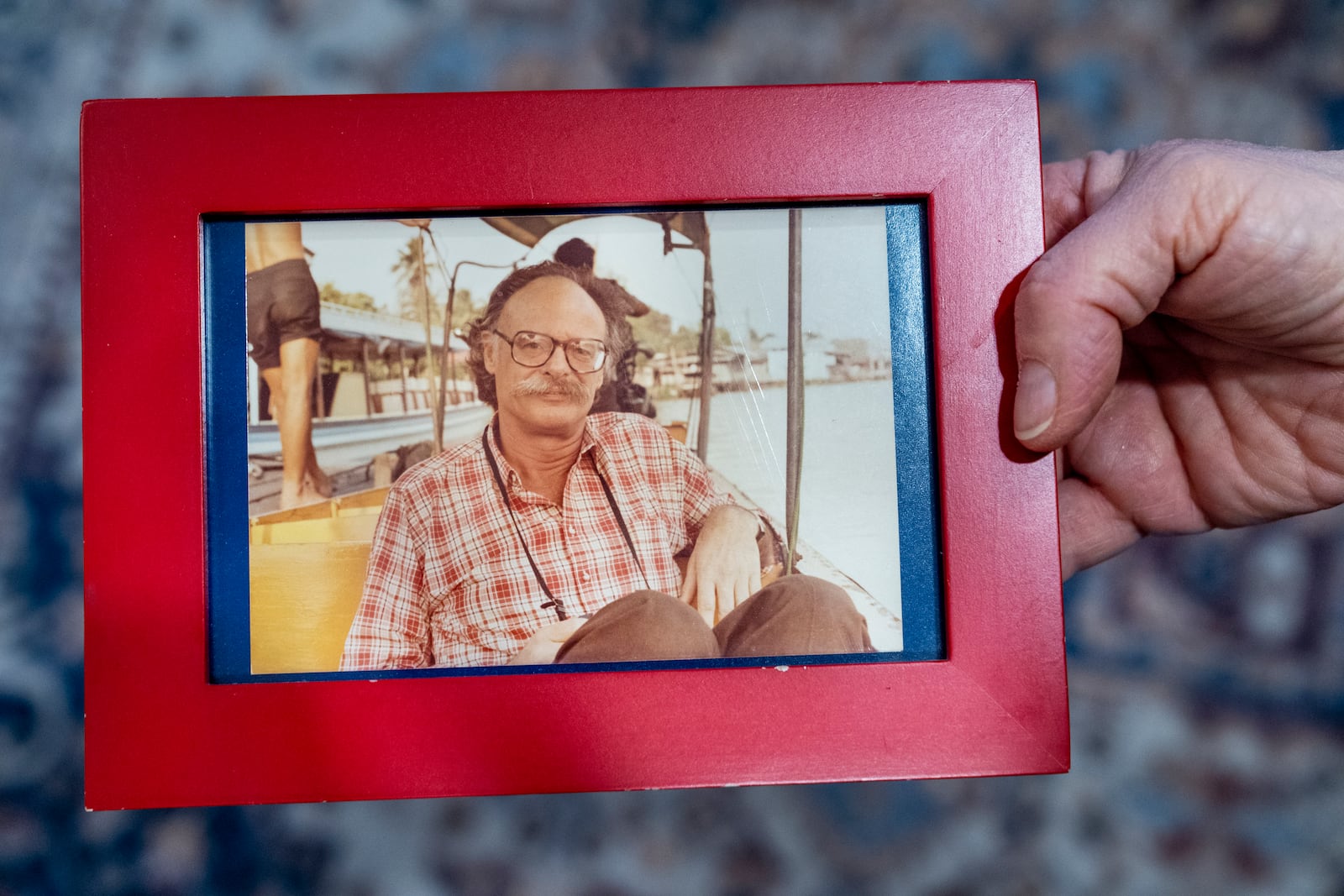 Cathy Votaw, 69, holds a photograph of her father, Albert Votaw, seen in Bangkok circa 1983 shortly before his death in a terror attack, Thursday, Feb. 27, 2025, in Washington. (AP Photo/Jacquelyn Martin)