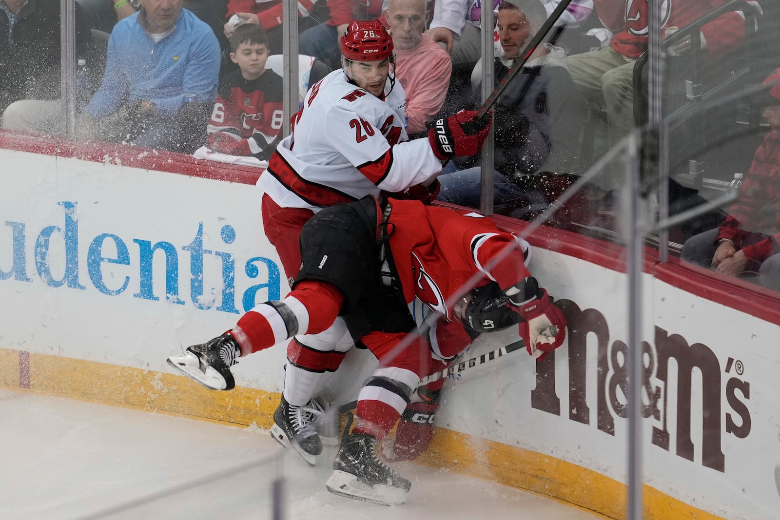 Carolina Hurricanes' Sean Walker, left, hits New Jersey Devils' Paul Cotter during the first period of Game 4 of an NHL hockey first-round series, Sunday, April 27, 2025, in Newark, N.J. (AP Photo/Seth Wenig)