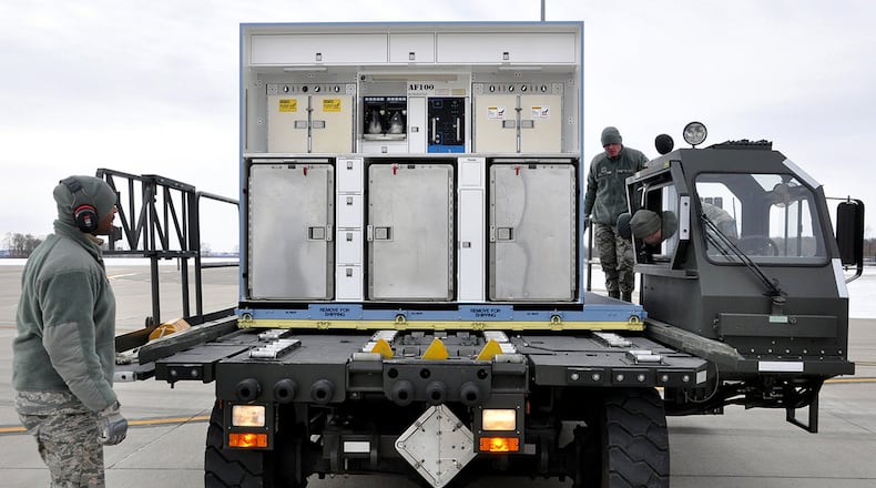 Senior Airman Michael Thompson (left) serves as part of the air transportation crew securing an air transportable galley-lavatory on a 25K Halvorsen Loader for Hickam Air Force Base, Hawaii, in support of exercise Sentry Aloha. Senior Airman Ryan Hood, ramp operations specialist, maneuvers the interior cab controls of the vehicle to operate the mechanized rollers and align the pallet with the steel locking system. (Contributed photo)