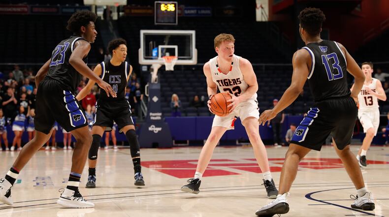 Jackson Center’s Aidan Reichert is guarded by three Cincinnati Christian defenders during their Division IV regional semifinal game on Tuesday night at UD Arena. Reichert had 18 points as the Tigers won 40-30. CONTRIBUTED PHOTO BY MICHAEL COOPER