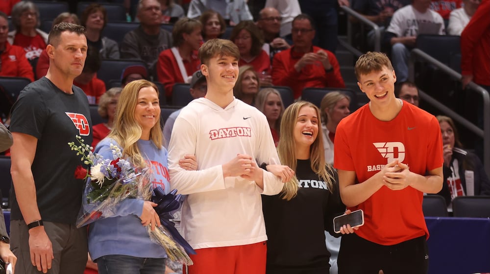 Aiden Derkack, right, claps as his brother Jordan, center, is introduced during Dayton's Senior Night ceremony on Friday, March 6, 2026, at UD Arena. Also pictured are Aiden's parents, Gene and Jenny, left of Jordan; and his sister Taylor, second from right. David Jablonski/Staff