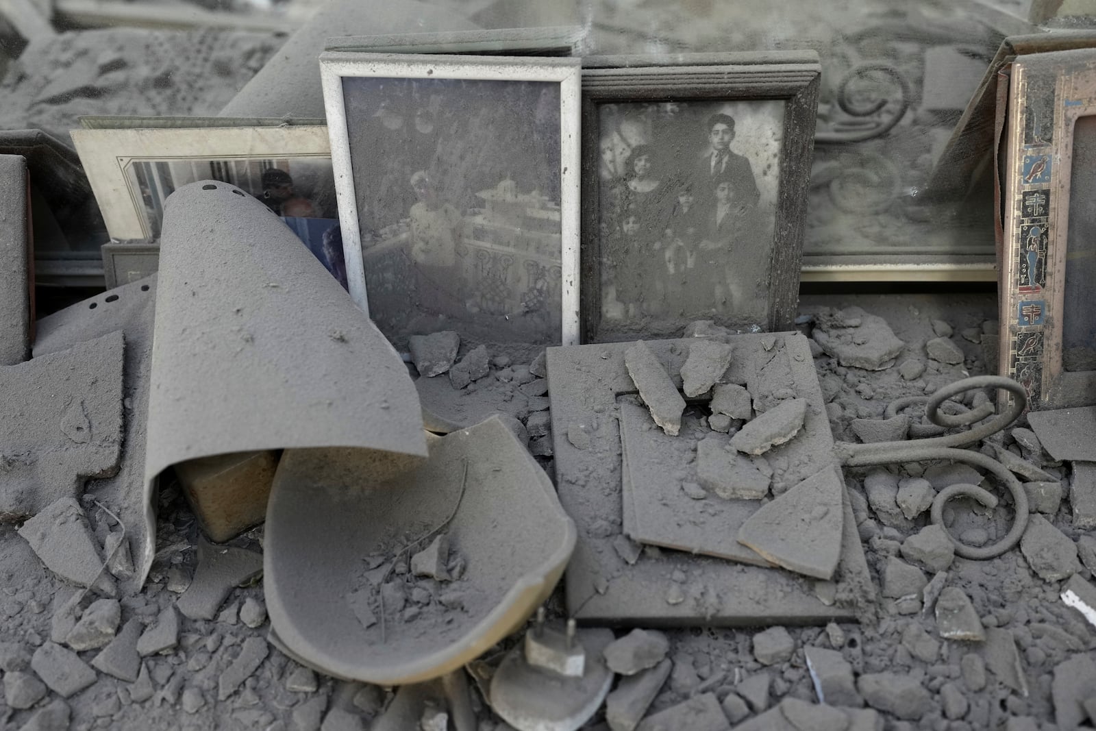 Dust covers framed family photos and personal objects at the site of a direct hit from an Iranian missile strike in Ramat Gan, Israel, Thursday, June 19, 2025. (AP Photo/Oded Balilty)