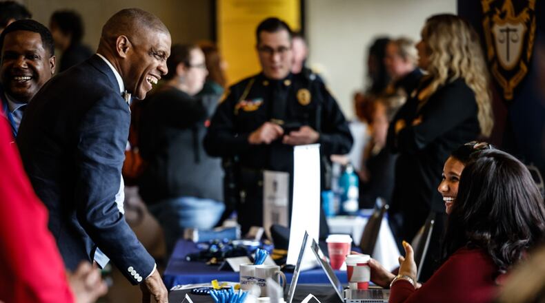 Dayton Public Schools employee Gary Armstrong, left talks with representatives from the city of Dayton Wednesday April 10, 2024. Sinclair hosted the fair which attracted near 100 employers. JIM NOELKER/STAFF