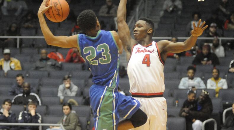 CJ’s Dominic Wilcox (with ball) is confronted by Trotwood’s Myles Belyeu. Trotwood defeated CJ 78-60 in a boys high school basketball D-II district final at UD Arena on Thu., March 8, 2018. MARC PENDLETON / STAFF